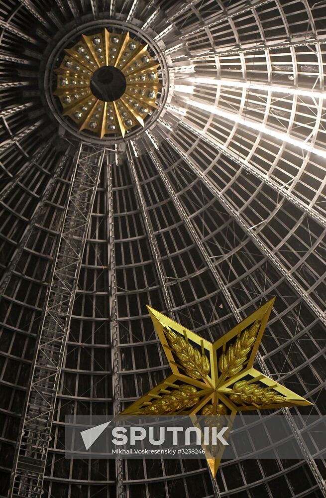 Installing star-shaped chandelier in Cosmos pavilion at VDNKh