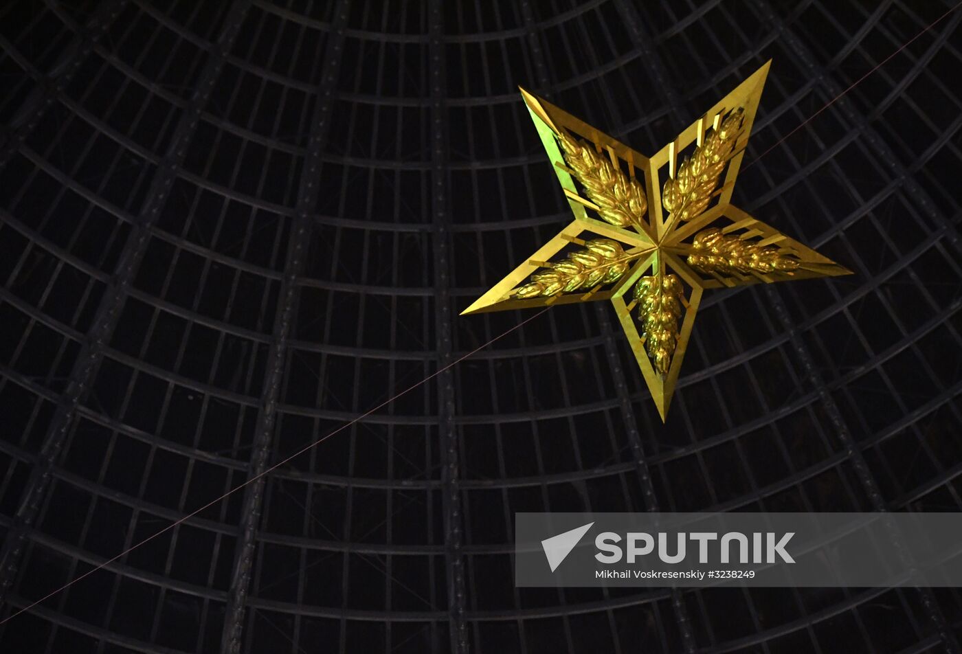 Installing star-shaped chandelier in Cosmos pavilion at VDNKh