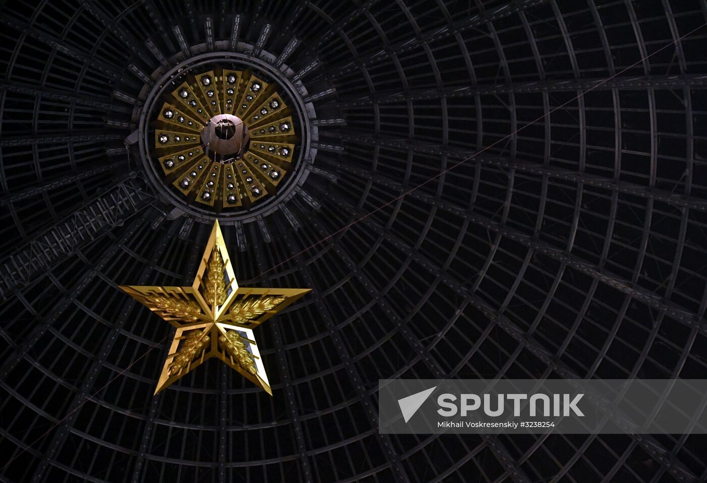 Installing star-shaped chandelier in Cosmos pavilion at VDNKh