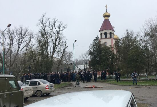 Leaving flowers outside St. George's Church in Kizlyar