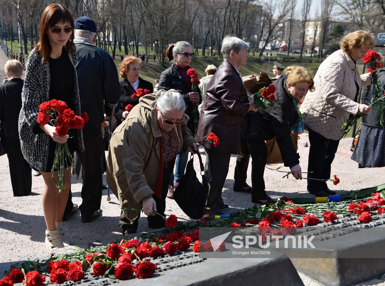 Laying flowers at Babiy Yar massacre memorial