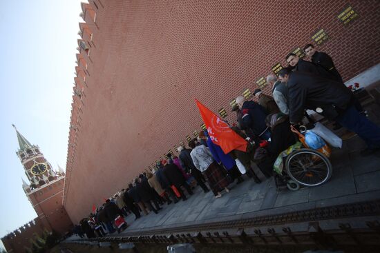 Laying flowers at Yuri Gagarin's grave near Kremlin Wall