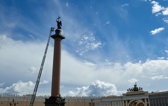 Cleaning angel sculpture on top of Alexander Column in St. Petersburg