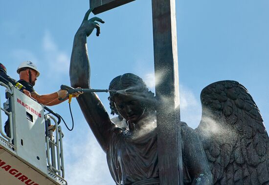 Cleaning angel sculpture on top of Alexander Column in St. Petersburg