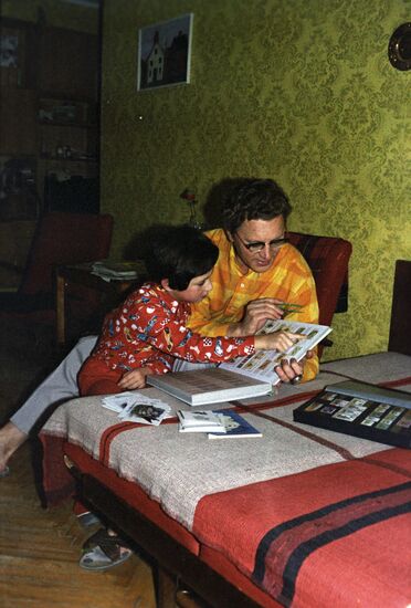 Father and daughter view stamp-album