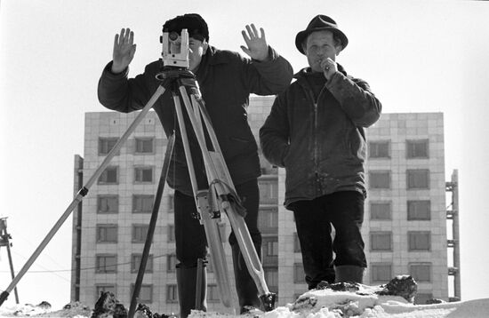 Land surveyors make measurements at construction site