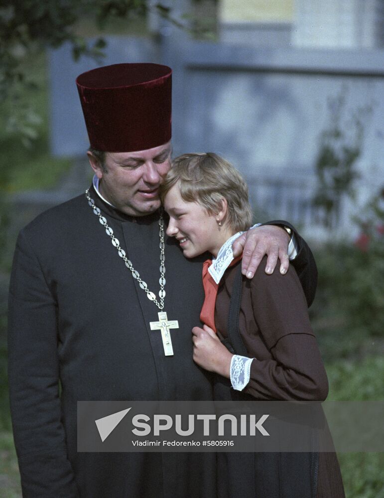 Orthodox priest with his daughter