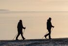People are silhouetted against the rising sun as they practice nordic walking on an embankment of the Lake Onega, in Petrozavodsk, Russia. Location: Russia, Republic of Karelia, Petrozavodsk. Author: Igor Podgornyi/Sputnik. Russia Karelia