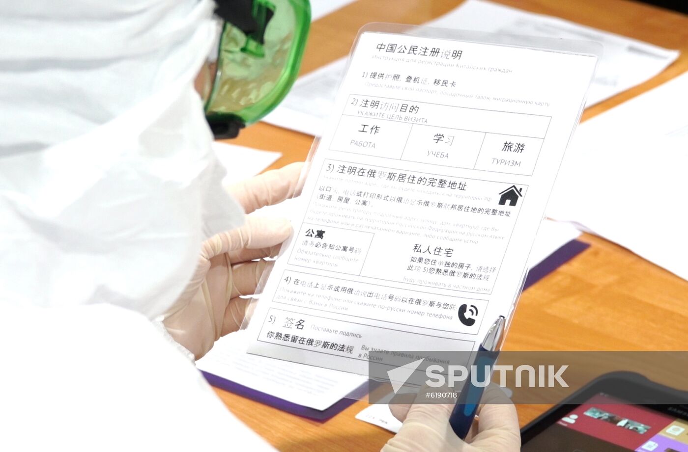 In this handout video grab distributed by the Moscow's Department of Healthcare, a member of Russian medical staff reads the manual for registration of Chinese citizens as she examines passengers, amid coronavirus outbreak, upon their arrival at Sheremetyevo International Airport, outside Moscow, Russia. Moscow Mayor Sergei Sobyanin has ordered to introduce a high-readiness regime in the Russian capital due to the threat of the spread of a new coronavirus infection, according to a decree published on the portal of the city government on 5.03. Editorial use only, no archive, no commercial use. Location: Russia, Moscow region. Russia New Coronavirus