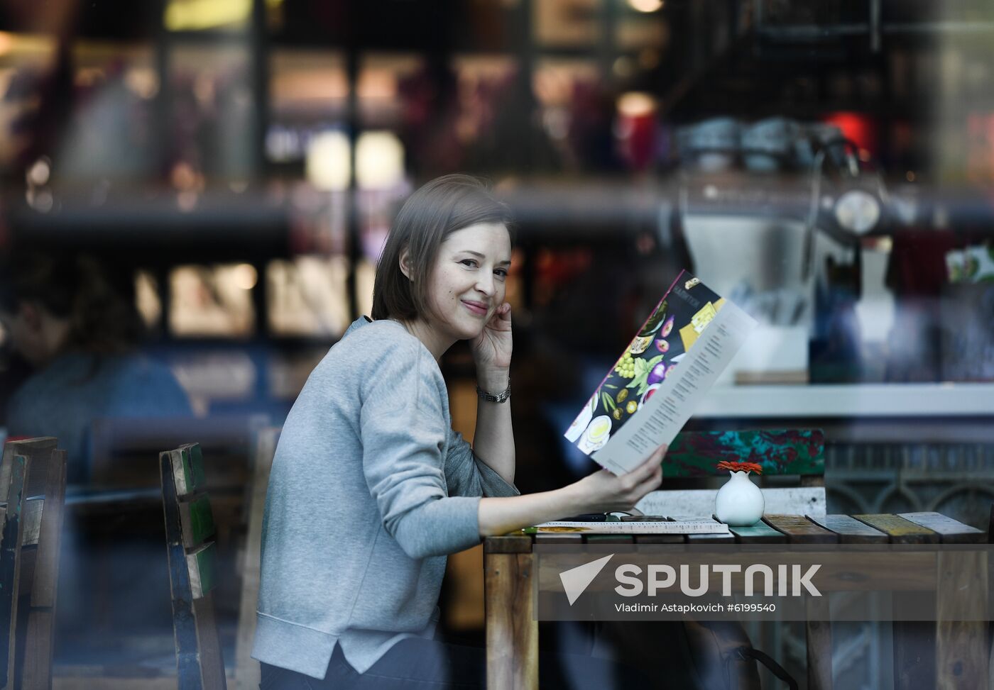 A woman smiles in a cafe amid concerns over the coronavirus disease spread in Moscow, Russia. Location: Russia, Moscow. Author: Vladimir Astapkovich/Sputnik. Russia Daily Life