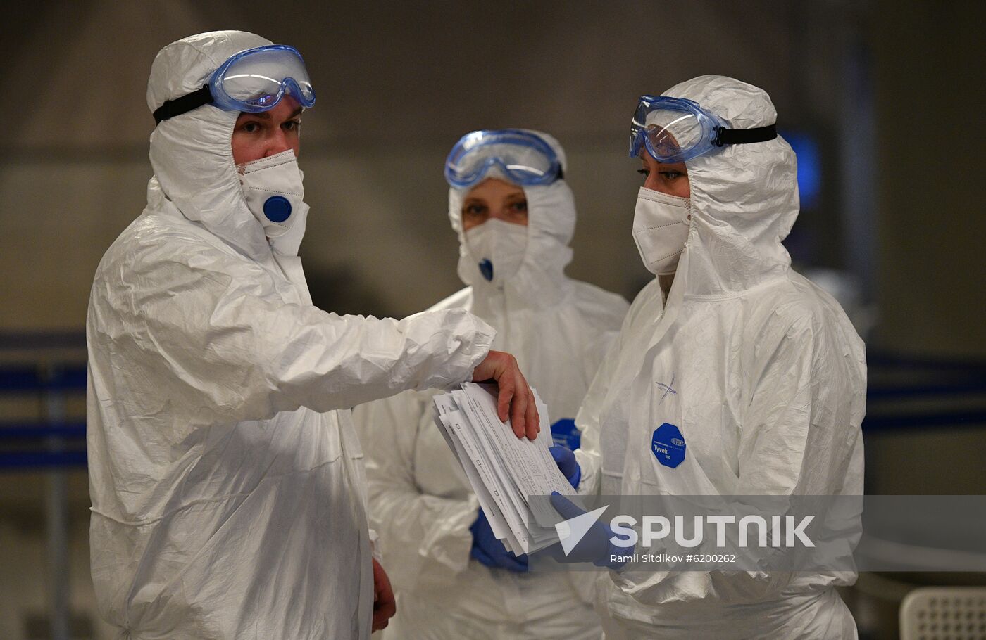 Medical workers wearing protective gears speak as they check passengers as a preventive measure against the coronavirus at Sheremetyevo International Airport outside Moscow, Russia. Location: Russia, Moscow. Author: Ramil Sitdikov/Sputnik. Russia Coronavirus