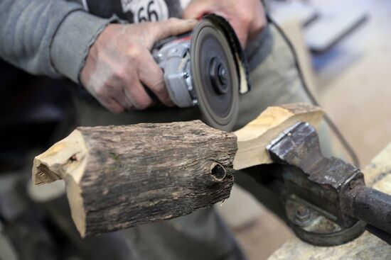 Wood carver Andrei Pisarev works during self-isolation at his country house
