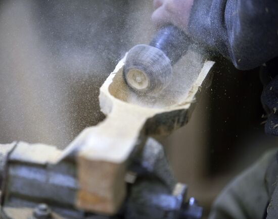 Wood carver Andrei Pisarev works during self-isolation at his country house