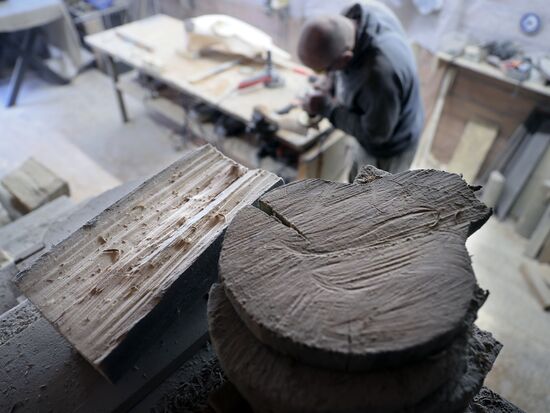 Wood carver Andrei Pisarev works during self-isolation at his country house