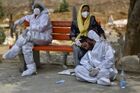 An exhausted health worker wearing personal protective equipment (PPE) rests at a bench at a graveyard, in Delhi, India. Location: India, Delhi. Author: Idrees Mohammed/Sputnik. India Coronavirus