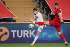 In this handout photo released by Russian Football Union, Russia's Daler Kuzyaev, left, hits the ball during the Nations League soccer match between Turkey and Russia, in Istanbul, Turkey. Editorial use only, no archive, no commercial use. Location: Turkey, Istanbul. Author: Mikhail Shapayev/Sputnik. Turkey Soccer Nations League Turkey - Russia