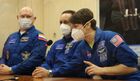 In this handout photo released by Russian Space Agency Roscosmos, from left, Roscosmos cosmonauts Oleg Artemyev, Anton Shkaplerov and NASA astronaut Ann McClain, members of the ISS-65 backup crew, speak behind a glass wall after checking the final configuration of the Soyuz MS-18 spacecraft named after Soviet cosmonaut Yuri Gagarin at the Baikonur cosmodrome, Kazakhstan. Editorial use only, no archive, no commercial use. Location: Baikonur. Kazakhstan Russia Space
