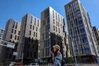 A woman talks over her phone with a newly built residential complex, in Moscow, Russia. Location: Russia, Moscow. Author: Vladimir Pesnya/Sputnik. Russia Residential Complex Construction