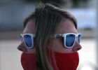 A woman wearing a protective face mask is reflected in a mirror on a street amid the outbreak of the coronavirus disease in Krasnoyarsk, Russia. Location: Russia, Krasnoyarsk. Author: Ilya Naymushin. Russia Coronavirus Daily Life