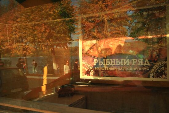 Embankment reflects in fish store's glass in Plyos