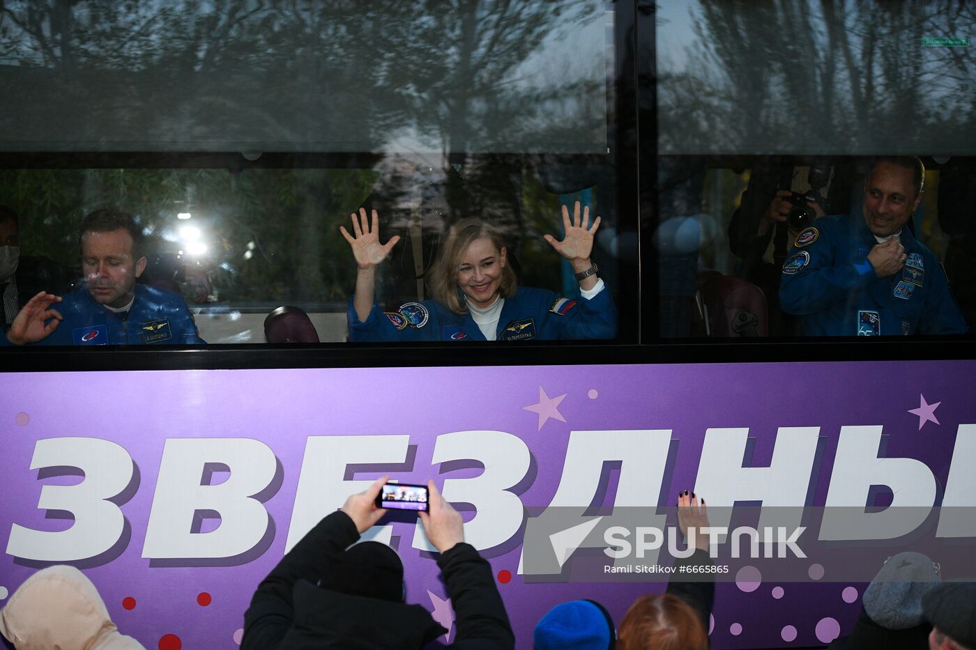 ISS Expedition 66 main crew members, actress Yulia Peresild, Roscosmos cosmonaut Anton Shkaplerov, and filmmaker Klim Shipenko gesture as they leave for the Baikonur Cosmodrome, in Baikonur, Kazakhstan. The launch of the Soyuz MS-19 mission to be involved in making the feature film "The Challenge" aboard the International Space Station is scheduled for 5 October 2021 at 11:55 Moscow time from the Baikonur Cosmodrome. Actor Yulia Peresild and director Klim Shipenko are set to blast off Tuesday for the International Space Station in a Russian Soyuz spacecraft together with cosmonaut Anton Shkaplerov, a veteran of three space missions. After 12 days on the space outpost, Peresild and Shipenko will return to Earth with another Russian cosmonaut. Location: Kazakhstan, Baikonur. Author: Ramil Sitdikov/Sputnik. Kazakhstan Russia Space