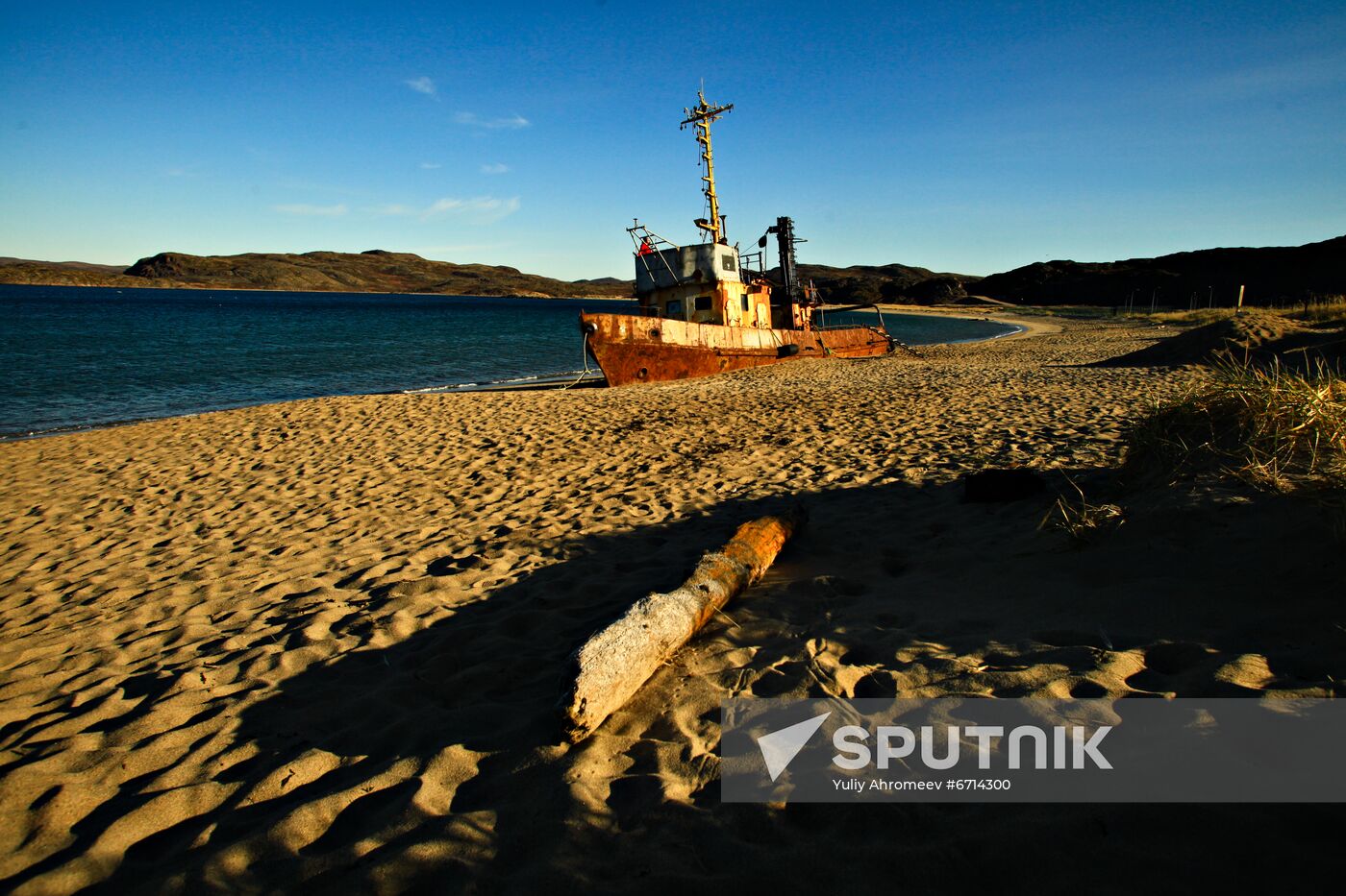 Corroded trawler on sandy beach in Teriberka