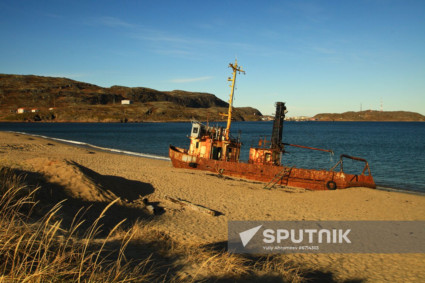 Corroded trawler on sandy beach in Teriberka