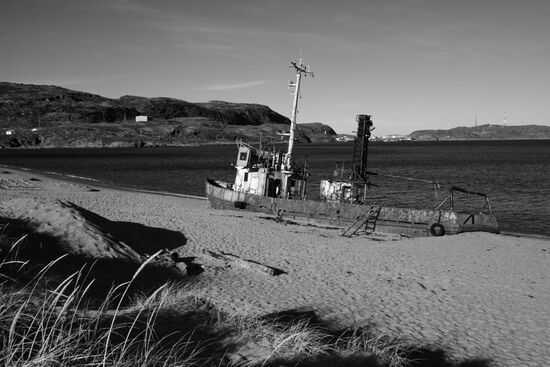 Rusty trawler on sandy beach in Teriberka