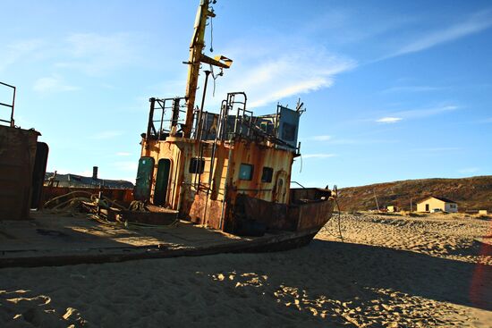 Rusty trawler on sandy beach in Teriberka