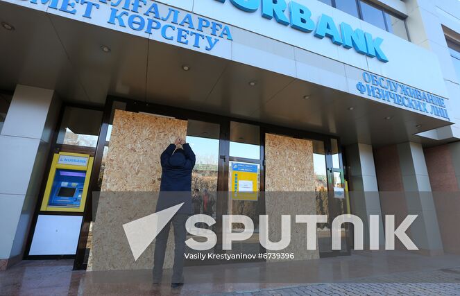 A man covers a broken window of Nurbank's office with a fiberboard plate, in Almaty, Kazakhstan. Protests sparked by rising fuel prices, started in the towns of Zhanaozen and Aktau in western Kazakhstan on January 2 and spread rapidly across the country. On January 5, President Tokayev dismissed the government and declared a 2-week state of emergency in the Mangistau and Almaty regions, as well as in the cities of Almaty and Nur-Sultan. Location: Kazakhstan, Almaty. Author: Vasily Krestyaninov/Sputnik. Kazakhstan Protests Aftermath
