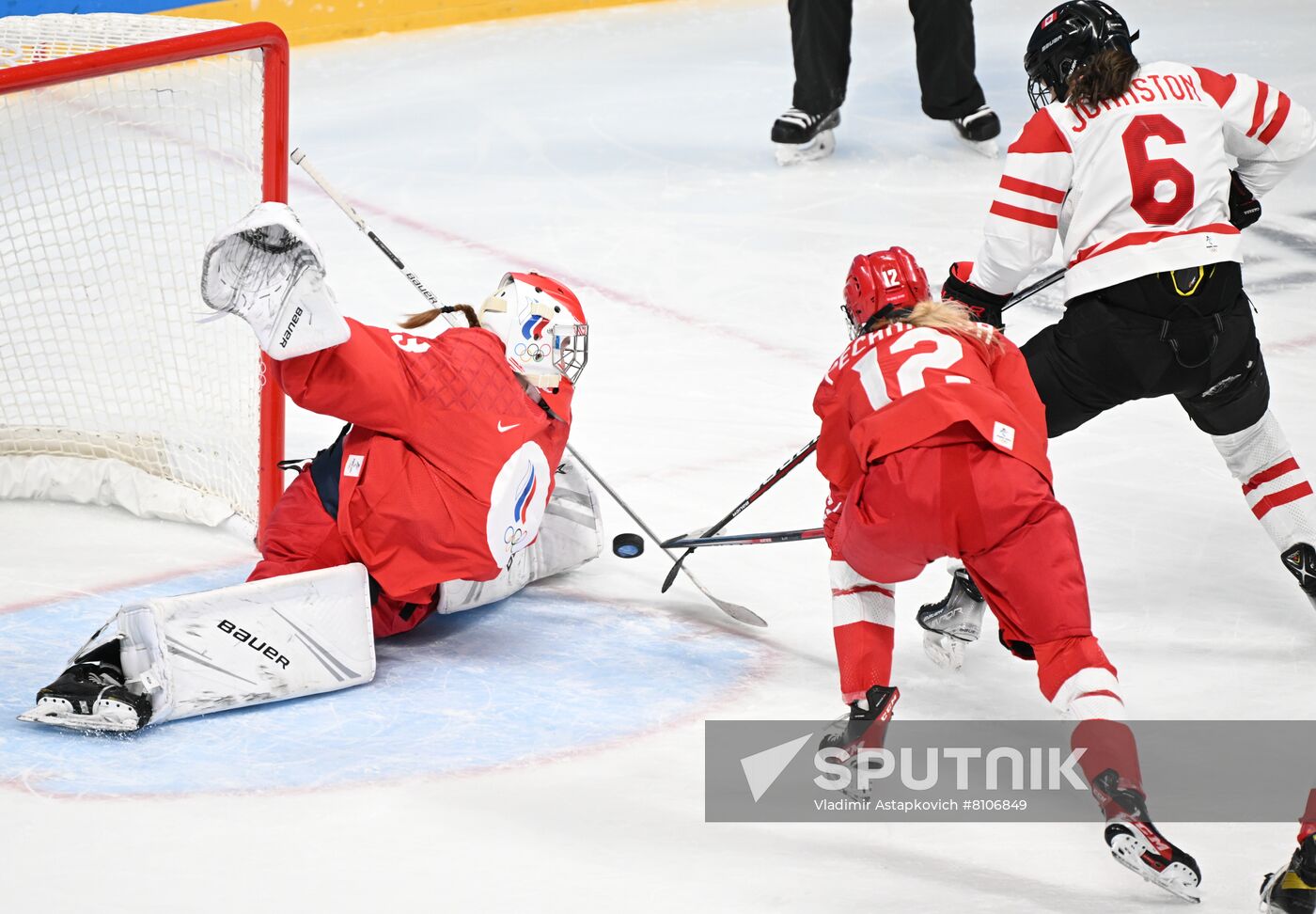 From left, Russian Olympic Committee's goaltender Daria Gredzen, Russian Olympic Committee's Maria Pechnikova and Canada's Rebecca Johnston struggle for a puck in the ice hockey women's preliminary round group A match between the Russian Olympic Committee's team and Canada during the Beijing 2022 Winter Olympic Games at Wukesong Sports Centre in Beijing, China. Location: China, Beijing. Author: Vladimir Astapkovich/Sputnik. China Olympics 2022 Ice Hockey Women ROC - Canada