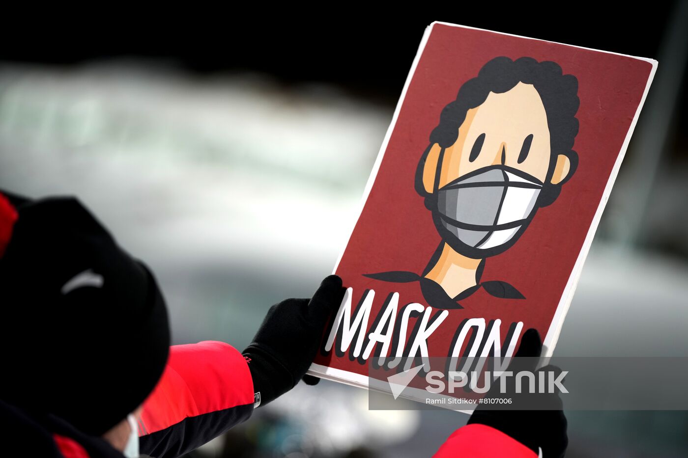 A volunteer holds a placard with the instruction to keep protective face masks on during the biathlon women's 15 km individual competition during the Beijing 2022 Winter Olympic Games at National Biathlon Centre, in Zhangjiakou, China. Location: China, Zhangjiakou. Author: Ramil Sitdikov/Sputnik. China Olympics 2022 Biathlon Women