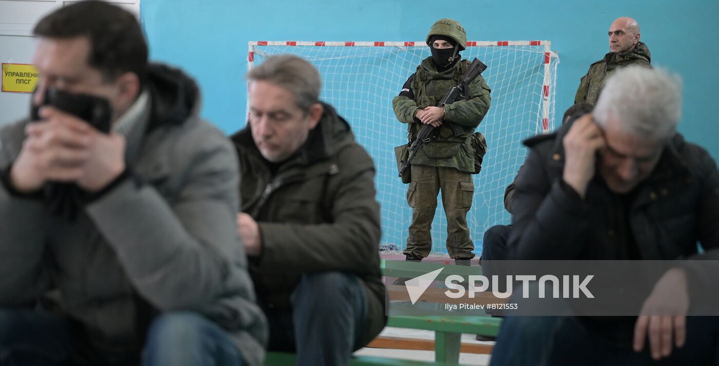 A militant of the self-proclaimed Donetsk People's Republic stands guard as men gather at a military mobilization point opened in a school in the city of Donetsk, the self-proclaimed Donetsk People's Republic, Ukraine. On February 19, the leaders of the self-proclaimed Donetsk and Luhansk People's republics signed decrees on full military mobilization. Location: Ukraine, Donetsk. Author: Ilya Pitalev/Sputnik. Ukraine DPR Tension Military Mobilization