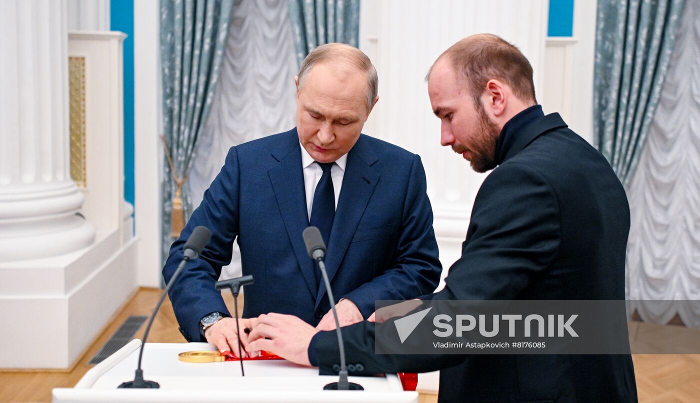 Russian President Vladimir Putin and Olympic champion in cross-country skiing Alexey Chervotkin attend a state awards ceremony for Russian athletes - gold medalists of the 2022 Beijing Olympic Winter Games at the Kremlin in Moscow, Russia. Location: Russia, Moscow. Author: Vladimir Astapkovich/Sputnik. Russia Putin Olympic Medalists