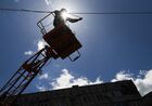 An electrician removes parts of a power pole to rebuild power lines on one of the streets in Mariupol, Donetsk People's Republic. Location: Donetsk People's Republic, Mariupol. Author: Alexey Kudenko/Sputnik. DPR LPR Russia Ukraine Military Operation