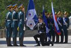 A Russian Federal Guard Service cadet knees before a banner during a graduation ceremony on Sobornaya Square of the Moscow Kremlin, Russia. Location: Russia, Moscow. Author: Evgeny Biyatov. Russia Federal Guard Service Cadets Graduation