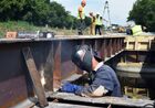 Workers reconstruct a bridge over the Krynka River on the Donetsk-Luhansk highway near the village of Nizhnyaya Krynka, in the Donetsk People's Republic. Location: Donetsk People's Republic. Author: Sergey Baturin/Sputnik. DPR Russia Ukraine Military Operation Bridge Reconstruction