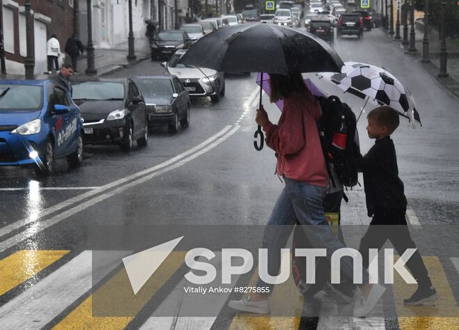 People walk under umbrellas on a pedestrian crossing during the rain in Vladivostok, Russia. Location: Russia, Vladivostok. Author: Vitaliy Ankov/Sputnik. Russia Weather