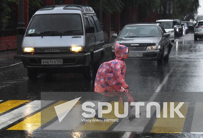 A girl wearing a raincoat walks on a pedestrian crossing during the rain in Vladivostok, Russia. Location: Russia, Vladivostok. Author: Vitaliy Ankov/Sputnik. Russia Weather