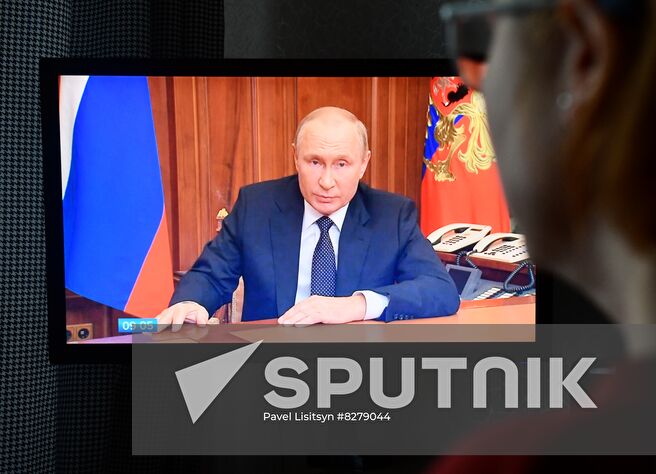 A woman watches a television showing Russian President Vladimir Putin addressing the nation, in Yekaterinburg, Russia. Putin on September 21 announced a partial mobilization for Russian citizens a day after Luhansk and Donetsk People's Republics, and Russian-controlled Zaporizhzhia and Kherson regions in southern Ukraine announced plans to hold votes on becoming integral parts of Russia. Location: Russia, Yekaterinburg. Author: Pavel Lisitsyn/Sputnik. Russia Putin Address Broadcast