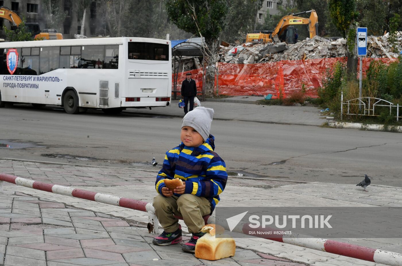 A bay eats bread in a street, as Russia's military operation in Ukraine continues, in the port city of Mariupol, Donetsk People's Republic. Location: Donetsk People's Republic, Mariupol. Author: RIA Novosti/Sputnik. DPR Russia Ukraine Military Operation Daily