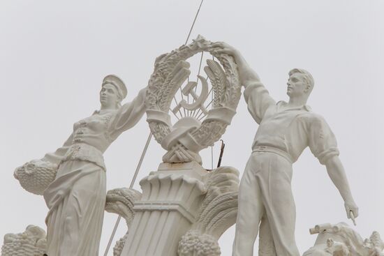 Returning figures of Collective Farmer and Collective Farm Woman to roof of Chemistry Pavilion at VDNKh