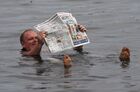 A man reads a newspaper as he floats in the salt waters of Tus lake while staying at a tourist camp in the Republic of Khakassia, Russia. Tourists from different regions annually arrive at the lake to live in a camp, bathe in the bitter-salty water and smear themselves with curative mud. Location: Russia, Republic of Khakassia. Author: Ilya Naymushin/Sputnik. Russia Tourism