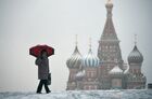 A woman with an umbrella walks at Red Square, with St. Basil's Cathedral in the background, during a snowfall in Moscow, Russia. Location: Russia, Moscow. Author: Maksim Blinov. Russia Weather