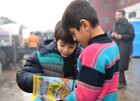Refugee boys look through the book at the Bruzgi logistics centre providing accommodation to migrants near the Bruzgi-Kuznica Bialostocka border crossing at the Belarusian-Polish border in Grodno region, Belarus. Migrants from the Middle East and North Africa trapped in Belarus have converged on the border with Poland, where razor wire fences and Polish troops have repeatedly blocked their entry. Location: Belarus, Grodno Region. Author: Pavel Bednyakov/Sputnik. Belarus Poland Border Refugees