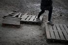 A refugee walks on pallets at the Bruzgi logistics centre providing accommodation to migrants near the Bruzgi-Kuznica Bialostocka border crossing at the Belarusian-Polish border in Grodno region, Belarus. Migrants from the Middle East and North Africa trapped in Belarus have converged on the border with Poland, where razor wire fences and Polish troops have repeatedly blocked their entry. Location: Belarus, Grodno Region. Author: Pavel Bednyakov/Sputnik. Belarus Poland Border Refugees
