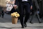 A man carries a bag with a bunch of roses while walking down the Kuznetsky Most street on a sunny April day in downtown Moscow, Russia. Location: Russia, Moscow. Author: Pavel Bednyakov/Sputnik. Russia Daily Life