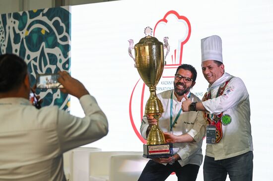 Participants in the International Cup of Chefs held as part of the 14th Russia - Islamic World: KazanForum International Economic Forum taking photos with the cup before it is presented to the winner. The award ceremony will take place on May 18. Crediting the source is mandatory when using the photo. Location: Russia, Republic of Tatarstan, Kazan. Author: Svetlana Shevchenko/ANO “Directorate for Sports and Social Projects”. KAZANFORUM 2023. Dialogue of Cultures: Opening of the International Cup of Chefs KazanForum 2023