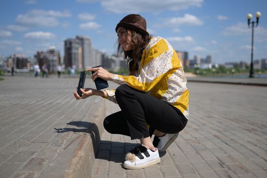 A forum participant is seen taking pictures in the park near the Kazan Family Center during a sightseeing tour of the city. Photos may be used as stated in the media bank section concerning the forum. Location: Russia, Republic of Tatarstan, Kazan. Author: Alexandr Kryazhev/ANO “Directorate for Sports and Social Projects”. KAZANFORUM 2023. Sightseeing tour of Kazan
