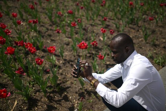 A guests of the forum taking photos of tulips near the Kazan Kremlin State Historical, Architectural and Artistic Reserve Museum during a sightseeing tour of the city. Photos may be used as stated in the media bank section concerning the forum. Location: Russia, Republic of Tatarstan, Kazan. Author: Alexandr Kryazhev/ANO “Directorate for Sports and Social Projects”. KAZANFORUM 2023. Sightseeing tour of Kazan